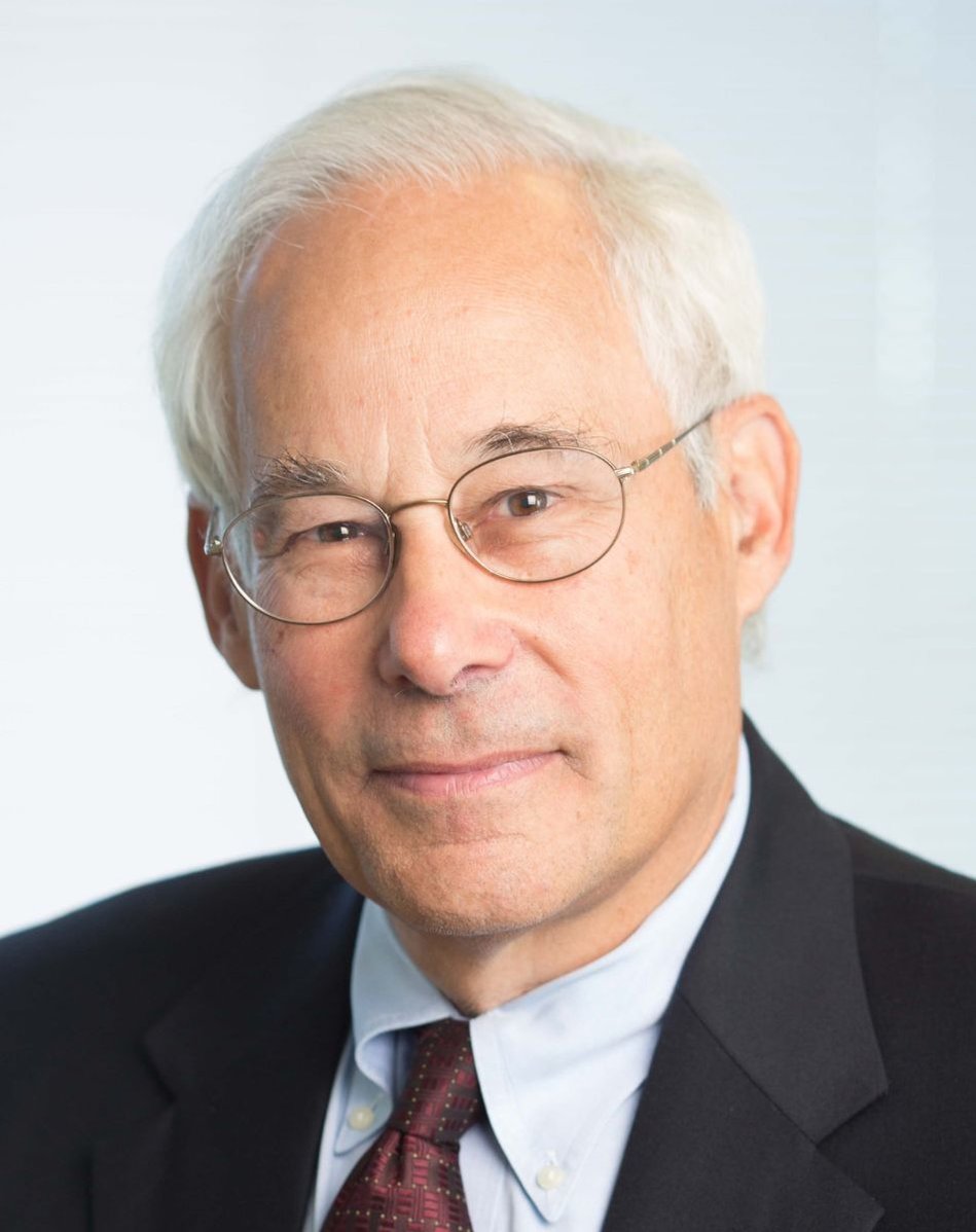 A headshot image of Don Berwick, wearing glasses, a suit, and a burgundy tie against a white background.