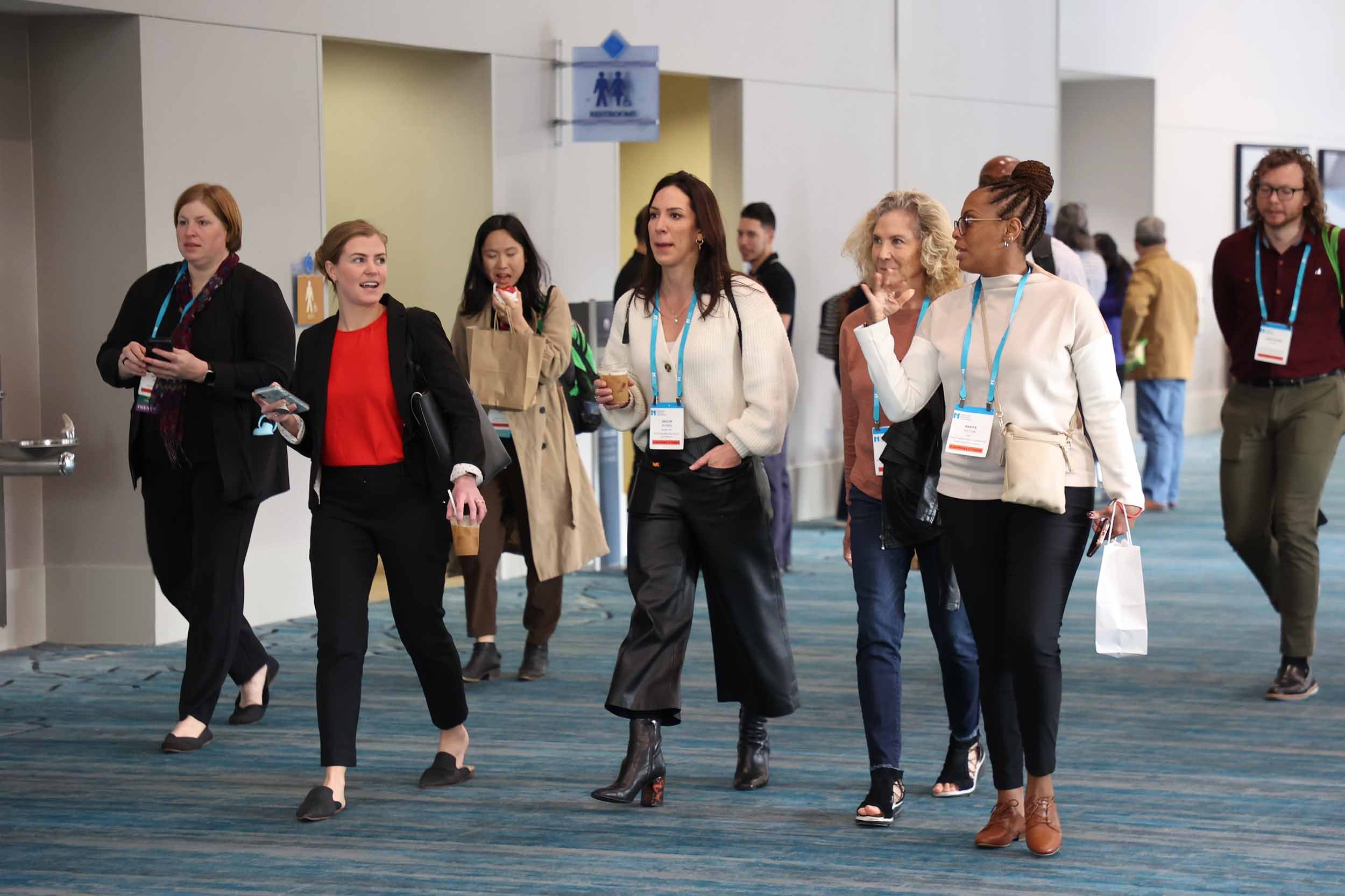 A group of female conference attendees walking down a hallway.